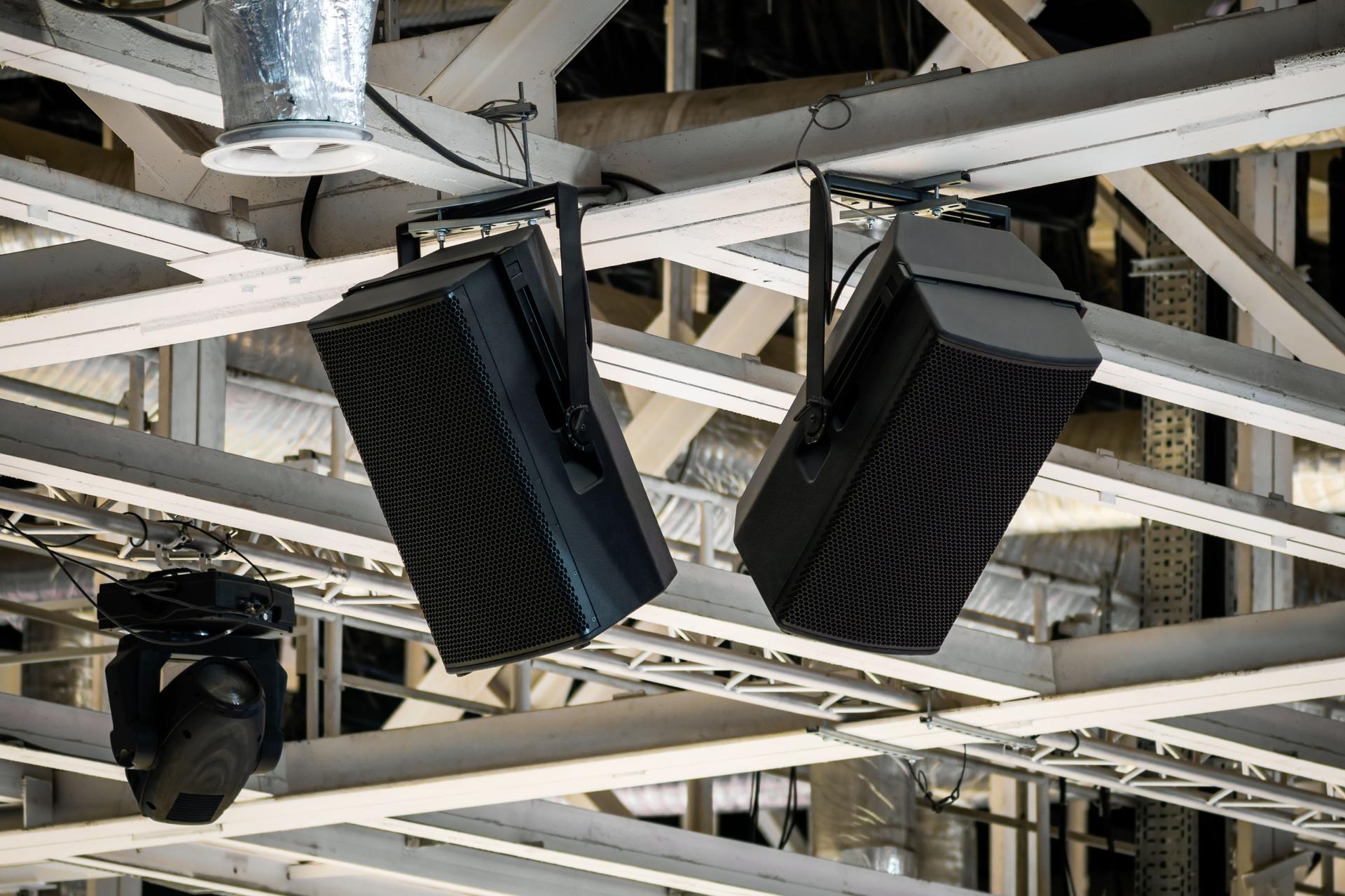 Potenti altoparlanti sospesi a strutture portanti sotto il soffitto di una grande arena